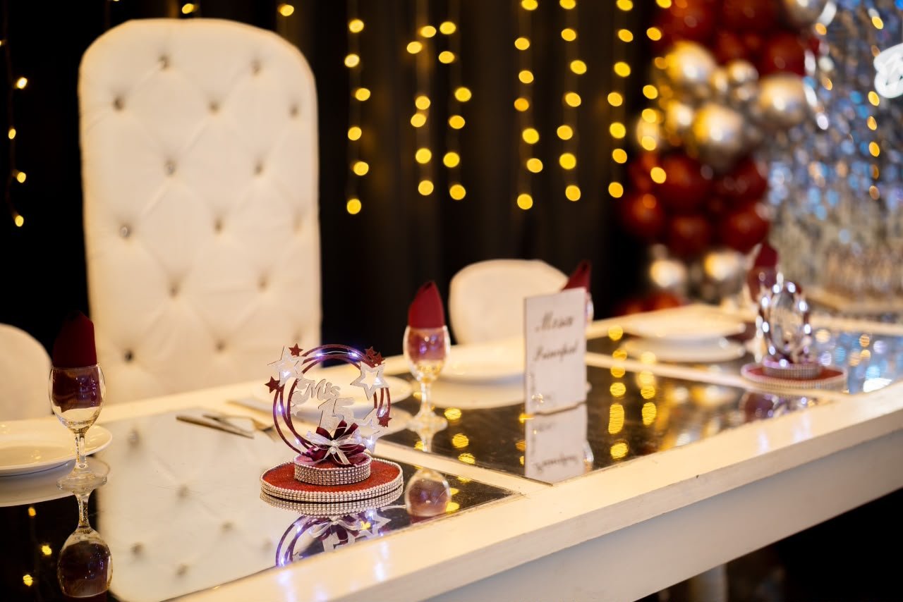 Mesa principal decorada con sillón tiffany y luces cálidas