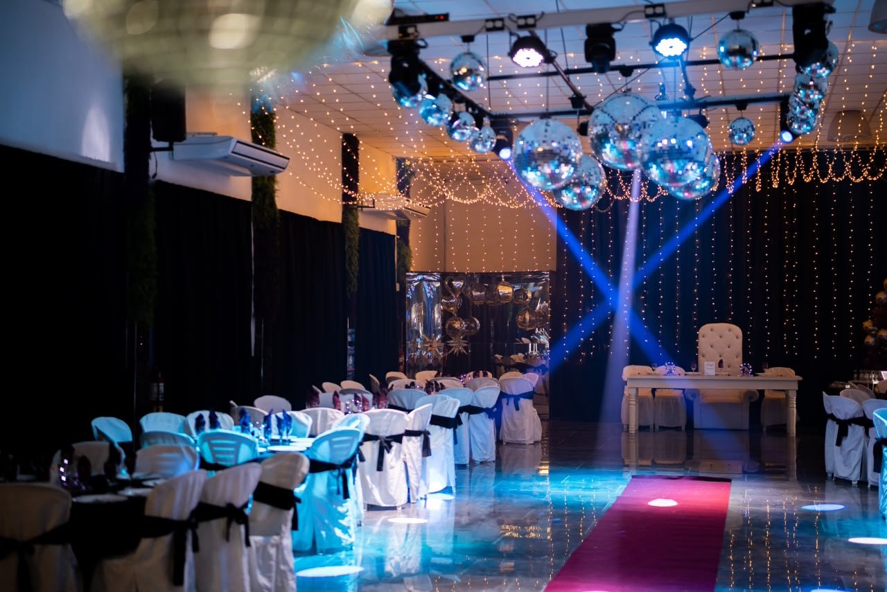 Vista general del salón con esferas, cortinas de luces y alfombra fucsia