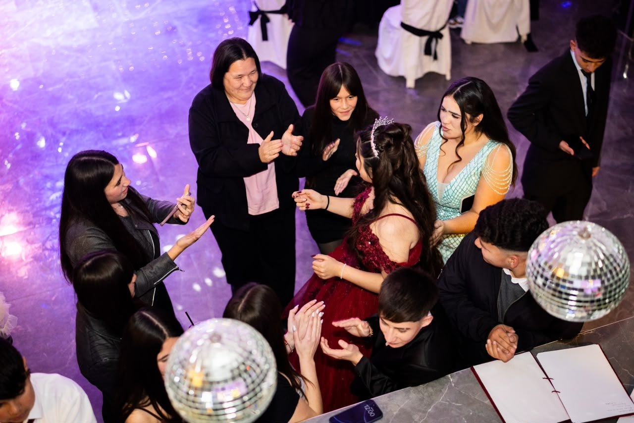 Quinceañera rodeada de sus invitados en la pista del salón